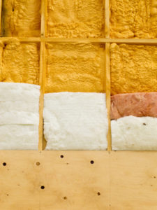 Different types of building insulation: polyurethane spray foam and fiberglas mats.